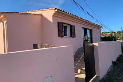 a small house with a white fence in front of it at Charmante villa 2 chambres les pieds dans l'eau Bonifacio in Bonifacio