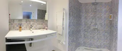 a bathroom with a sink and a shower with a mirror at Hôtel Cantu di Fiumu in Zonza