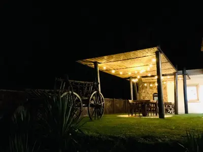 a night view of a patio with a table and lights at Hôtel Cantu di Fiumu in Zonza
