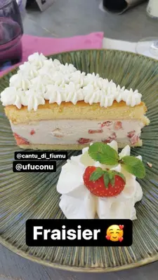 a piece of cake with whipped cream and a strawberry on a plate at Hôtel Cantu di Fiumu in Zonza