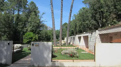a fence with two refrigerators in a yard at Hôtel Cantu di Fiumu in Zonza