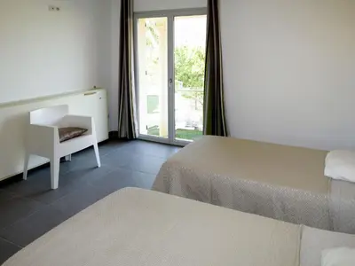 a bedroom with two beds and a desk and a window at Holiday Home Villa Ottavi by Interhome in Sainte-Lucie de Porto-Vecchio