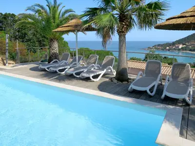 a row of lounge chairs next to a swimming pool at Holiday Home Villa Ottavi by Interhome in Sainte-Lucie de Porto-Vecchio