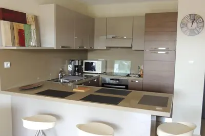 a kitchen with a counter with a sink and a microwave at Appartement vue piscine dans résidence de standing in Porto-Vecchio