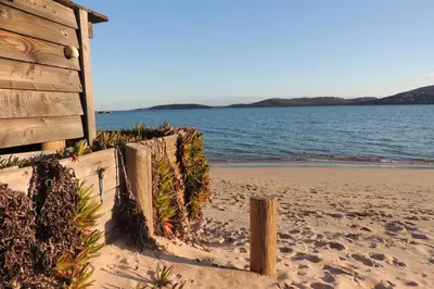a fence on the beach next to the ocean at Appartement vue piscine dans résidence de standing in Porto-Vecchio