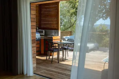 a patio with a blue couch and chairs on a balcony at SWIM LODGE HOTEL Piscine privée ou Jacuzzi privé in Porto-Vecchio
