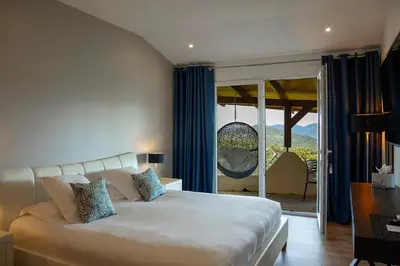 a bedroom with a bed and a television and a patio at SWIM LODGE HOTEL Piscine privée ou Jacuzzi privé in Porto-Vecchio