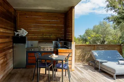 a bedroom with a bed and a tv on the wall at SWIM LODGE HOTEL Piscine privée ou Jacuzzi privé in Porto-Vecchio