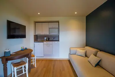 a living room with a couch and a table and a kitchen at SWIM LODGE HOTEL Piscine privée ou Jacuzzi privé in Porto-Vecchio