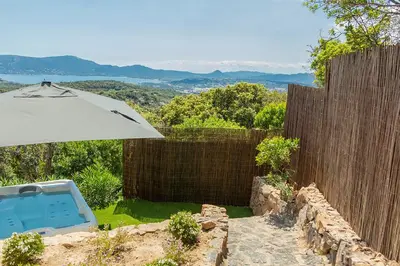 a patio with a table and a kitchen and a bed at SWIM LODGE HOTEL Piscine privée ou Jacuzzi privé in Porto-Vecchio