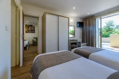 a hotel room with two beds and a desk at Résidence San Pellegrino in Folelli