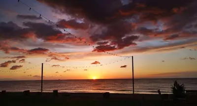 a sunset on the beach with a string of lights at Résidence San Pellegrino in Folelli