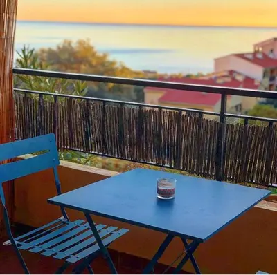 a blue table and a blue chair on a balcony at Magnifique T1 Bis Vue mer Route des sanguinaires Ajaccio in Ajaccio