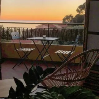 a patio with a table and chairs on a balcony at Magnifique T1 Bis Vue mer Route des sanguinaires Ajaccio in Ajaccio