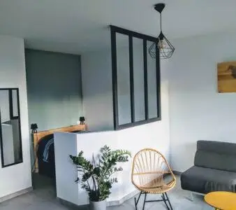 a living room with a couch and a chair at Magnifique T1 Bis Vue mer Route des sanguinaires Ajaccio in Ajaccio