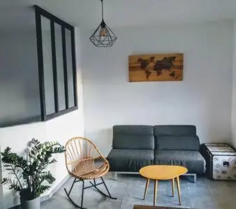 a living room with a couch and a table and chairs at Magnifique T1 Bis Vue mer Route des sanguinaires Ajaccio in Ajaccio