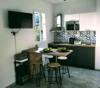 a kitchen with a table and bar stools in it at Magnifique T1 Bis Vue mer Route des sanguinaires Ajaccio in Ajaccio