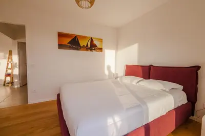 a bedroom with a large white bed with a red headboard at Casa Fiumu Oso in San-Gavino-di-Carbini