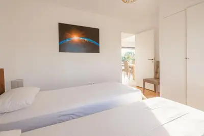 a white bedroom with a bed and a painting on the wall at Casa Fiumu Oso in San-Gavino-di-Carbini