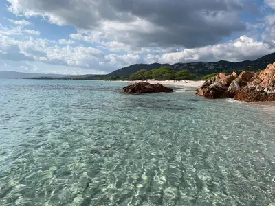a beach with rocks and the clear water at Casa Fiumu Oso in San-Gavino-di-Carbini
