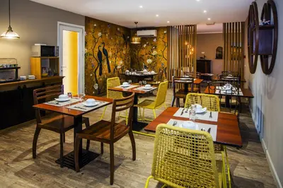 a restaurant with tables and chairs in a room at Résidence du pont de l'Oso in Porto-Vecchio