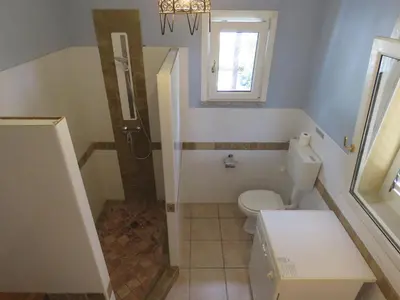 a small bathroom with a toilet and a shower at Résidence du pont de l'Oso in Porto-Vecchio