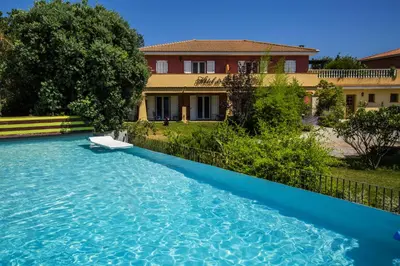 a swimming pool in front of a house at Résidence du pont de l'Oso in Porto-Vecchio