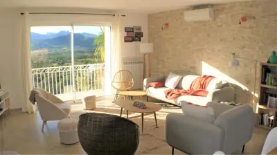 a living room with a couch and chairs and a balcony at VILLA CARAMONTINU SERENA à Pinarello, proche plage, vue mer, piscine chauffée in Zonza