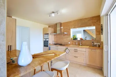a kitchen with a counter with a vase on it at VILLA CARAMONTINU SERENA à Pinarello, proche plage, vue mer, piscine chauffée in Zonza