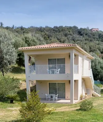 a large house with a balcony and a table at L'Alivu in Ajaccio