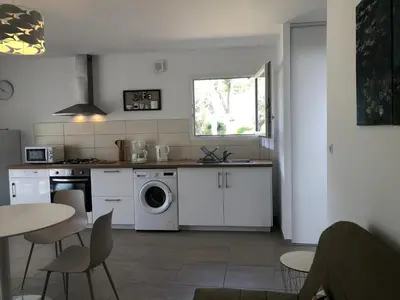a kitchen with a washing machine and a table and chairs at L'Alivu in Ajaccio