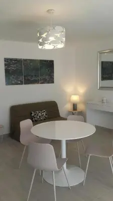 a living room with a white table and chairs at L'Alivu in Ajaccio