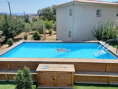 a large swimming pool with a deck and a house at L'Alivu in Ajaccio
