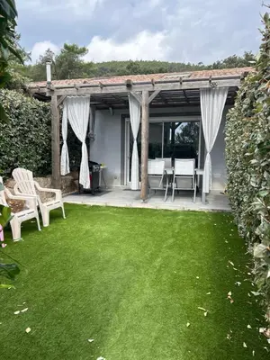 a garden with a patio and green lawn at Chez Muriel in Porto-Vecchio