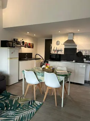 a kitchen with a table and chairs in a room at Chez Muriel in Porto-Vecchio