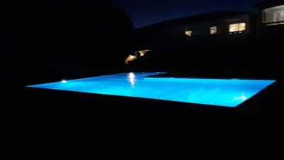 a swimming pool with blue lights in the dark at Mini Villa - Corse du Sud in Lecci