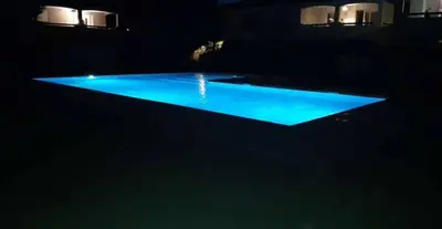 a swimming pool with blue lights in a dark room at Mini Villa - Corse du Sud in Lecci