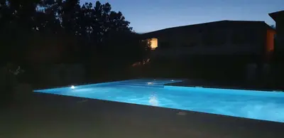 a large blue swimming pool at night at Mini Villa - Corse du Sud in Lecci