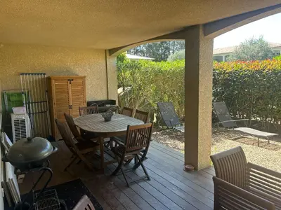 a patio with a table and chairs on a deck at Mini Villa - Corse du Sud in Lecci