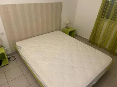 a bed in a room with a white mattress at Mini Villa - Corse du Sud in Lecci