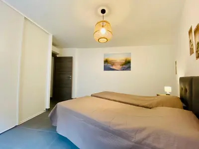 a bedroom with a bed and a light fixture at Fronte di Mare 2 chambres vue mer - 1 in Propriano