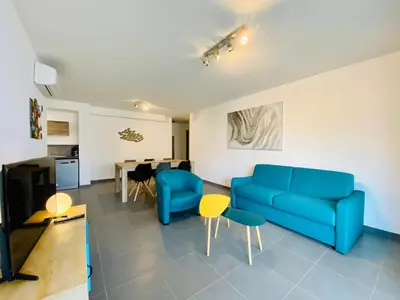 a living room with a blue couch and a table at Fronte di Mare 2 chambres vue mer - 1 in Propriano