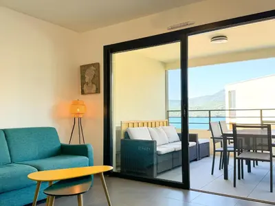 a living room with a couch and a table at Fronte di Mare 2 chambres vue mer - 1 in Propriano
