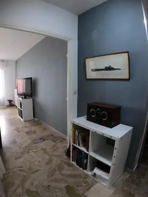 a living room with a book shelf and a tv at PASSERELLE DU MARIN in Ajaccio