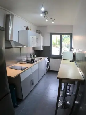 a kitchen with white cabinets and a counter top at PASSERELLE DU MARIN in Ajaccio