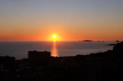 a sunset over the ocean with a city at PASSERELLE DU MARIN in Ajaccio