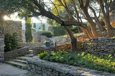 a stone wall and stairs in a garden at Domaine Panciarella in Saint-Florent