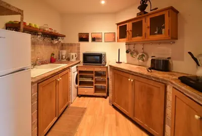a kitchen with wooden cabinets and a white refrigerator at Domaine Panciarella in Saint-Florent