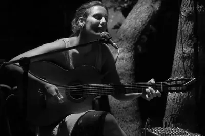 a woman playing a guitar and a microphone at Domaine Panciarella in Saint-Florent