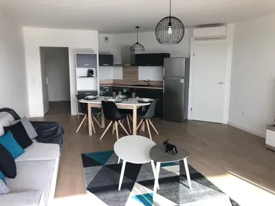 a living room and kitchen with a couch and a table at Bel appartement f3 vue sur le golfe d’ajaccio in Ajaccio